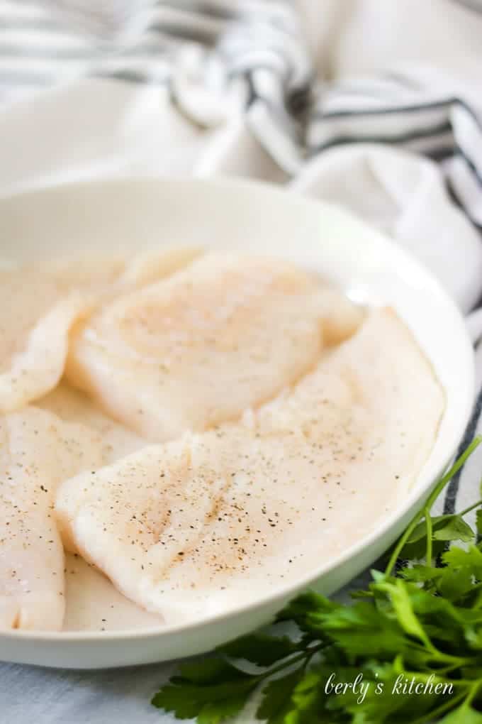 The raw fish has been placed on a plate and seasoned.