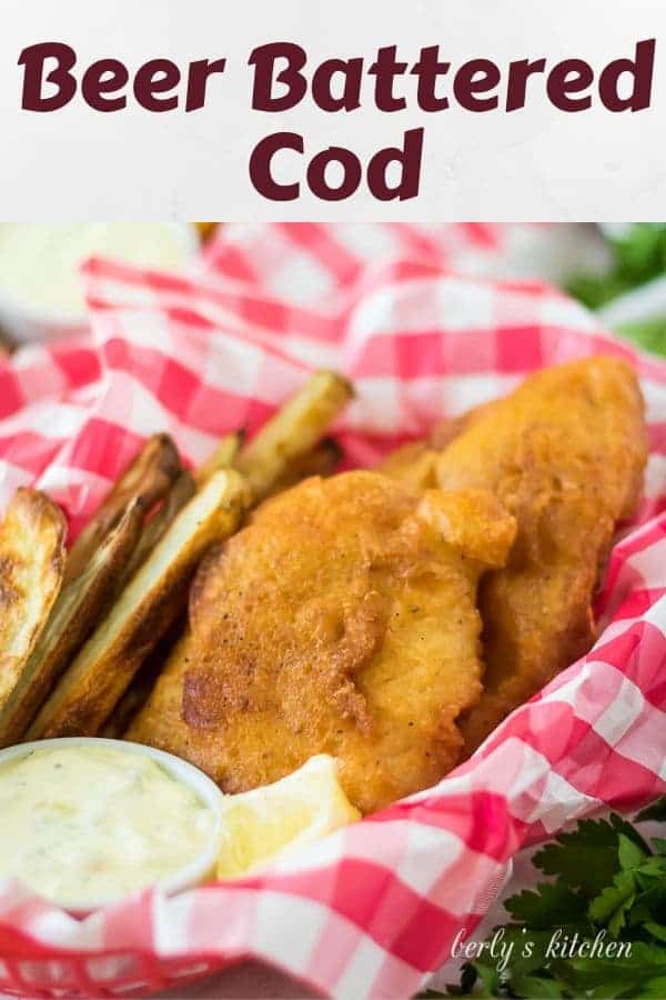 A basket with a checkered liner holding beer battered cod and fries.