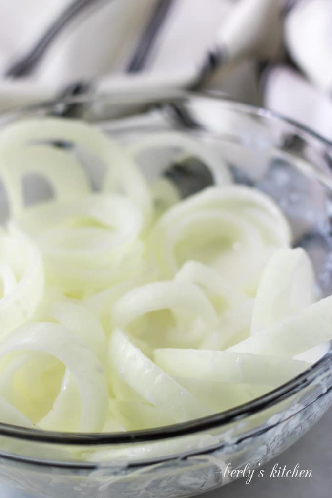 The onions have been sliced and tossed with buttermilk to coat them.