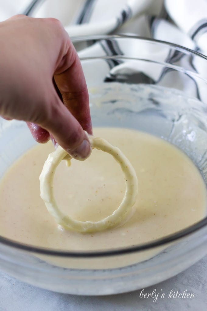 The floured ring being dipped into the wet beer batter.