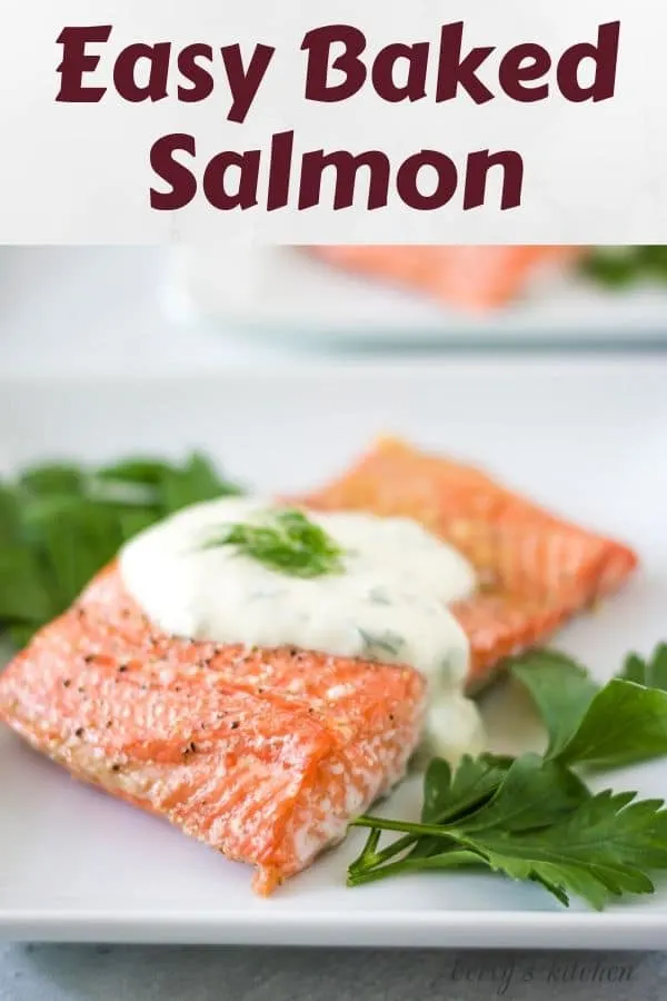 The finished easy baked salmon recipe on a plate with dill sauce.