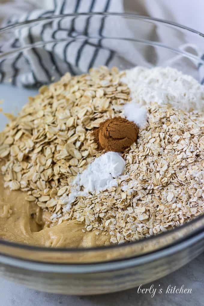 Flour, oats, and other ingredients have been added to the mixing bowl.