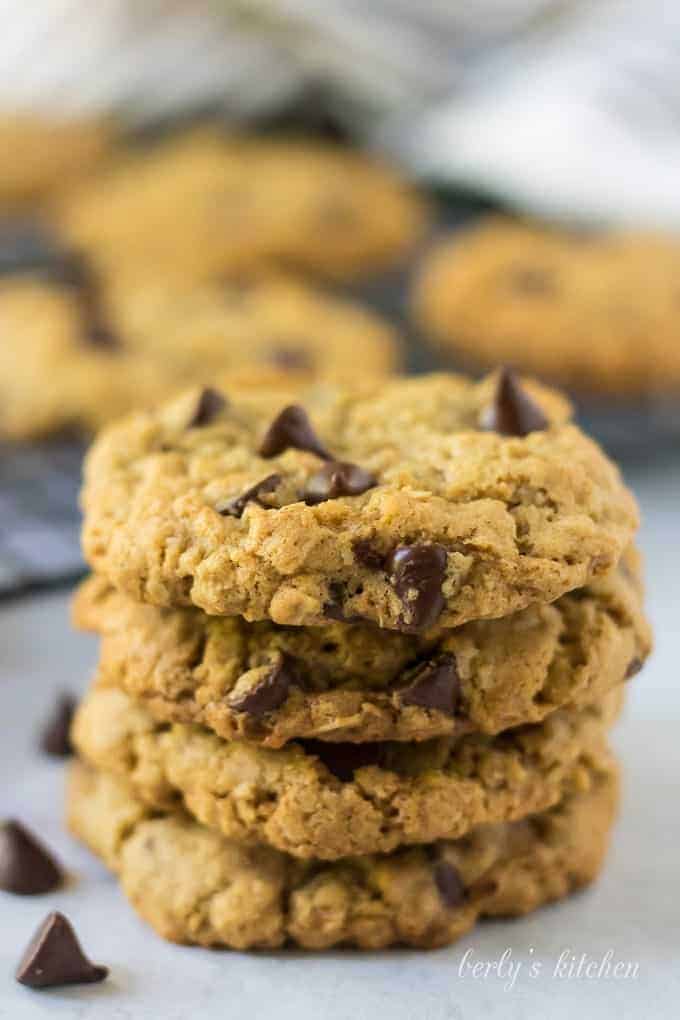 Multiple oatmeal chocolate chip cookies stacked up on each other.
