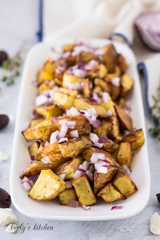 The cooked taters have been placed on the platter with diced onion.