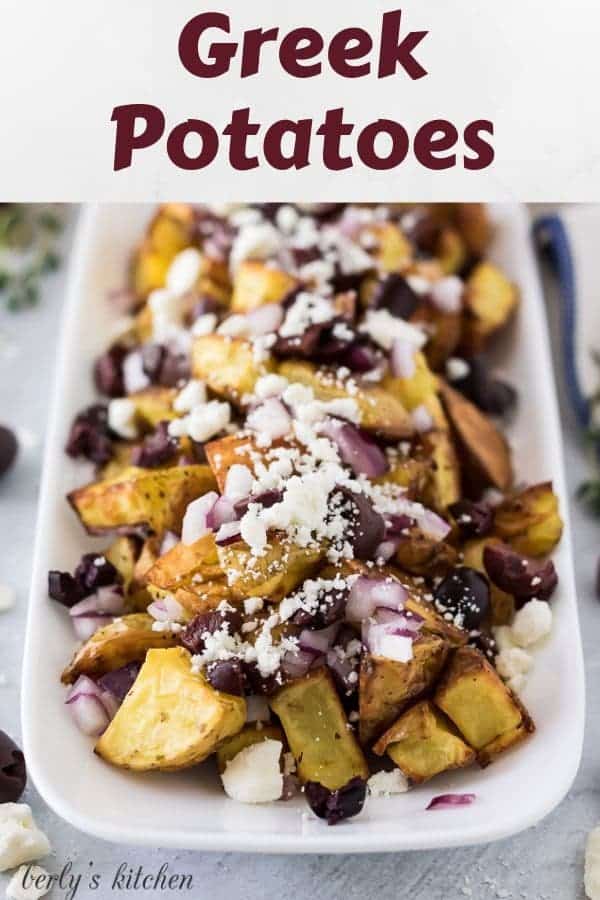 Close-up view of the greek potatoes covered in olives, onions, and cheese.