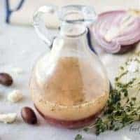 The vinaigrette served in a dressing bottle accented with herbs and olives.
