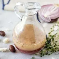 The vinaigrette served in a dressing bottle accented with herbs and olives.