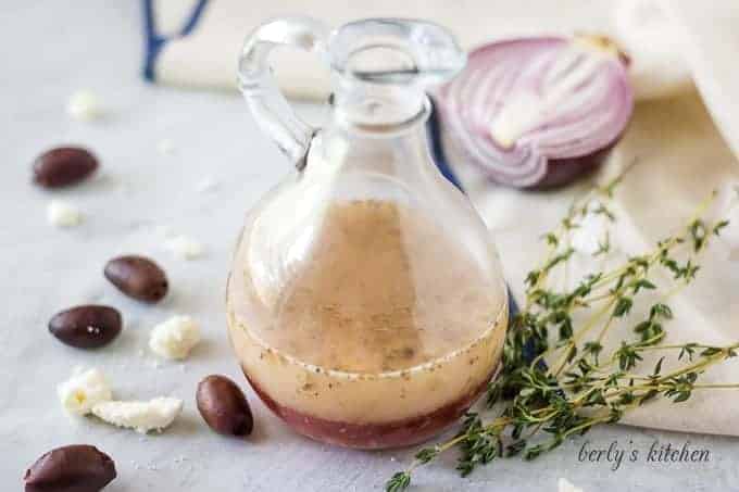 The vinaigrette served in a dressing bottle accented with herbs and olives.