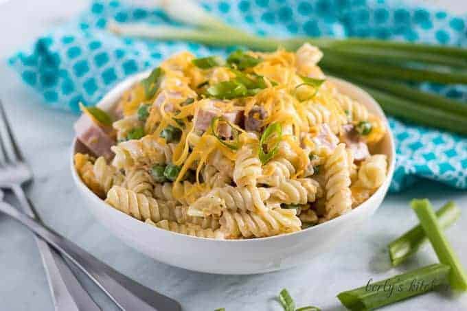 A large, white bowl of the ham and cheese pasta salad.