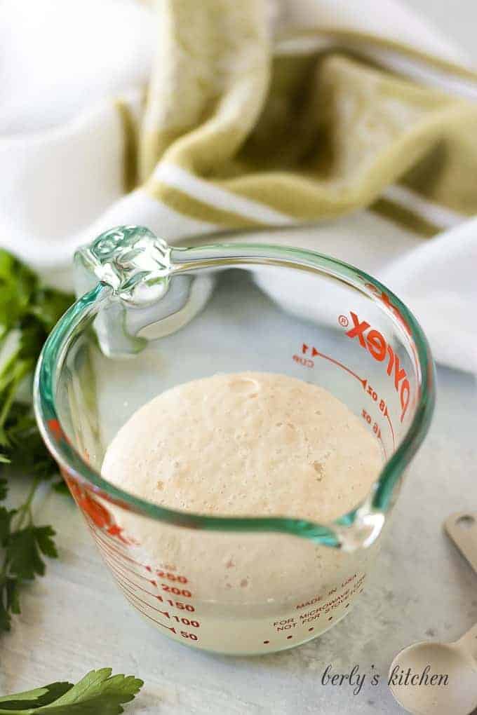 Activated yeast in a measuring cup.