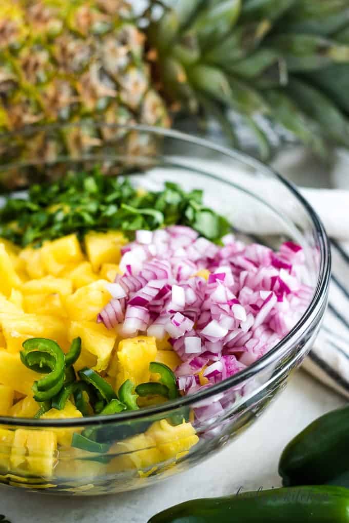 The red onions, jalapenos, and pineapple in a large mixing bowl.