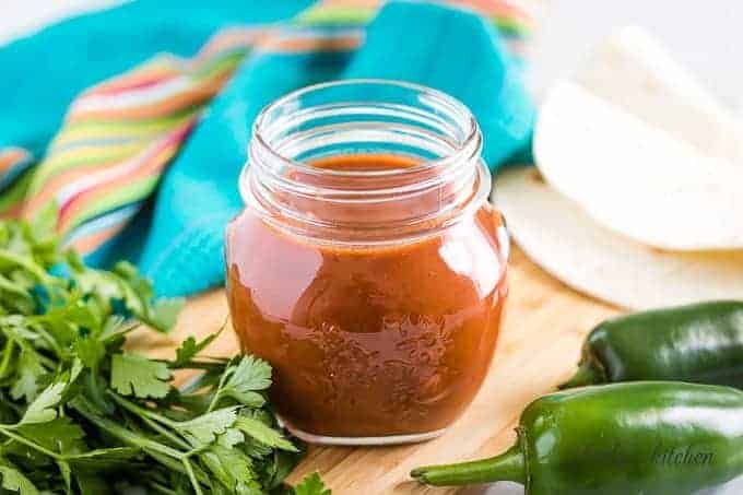 The tomato enchilada sauce in a mason jar accented with jalapenos.
