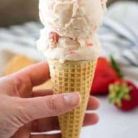 Two large scoops of strawberry ice cream in a waffle cone.