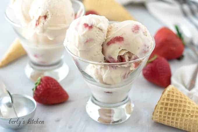 Three scoops of strawberry ice cream in a small cocktail glass.