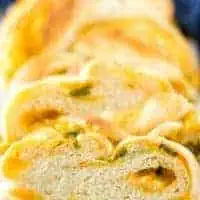 A loaf of jalapeno cheese bread with a blue linen.