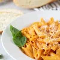 A close-up of the pasta garnished with basil and parmesan.