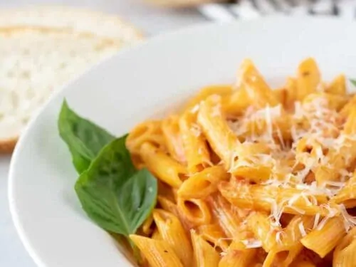 A close-up of the pasta garnished with basil and parmesan.