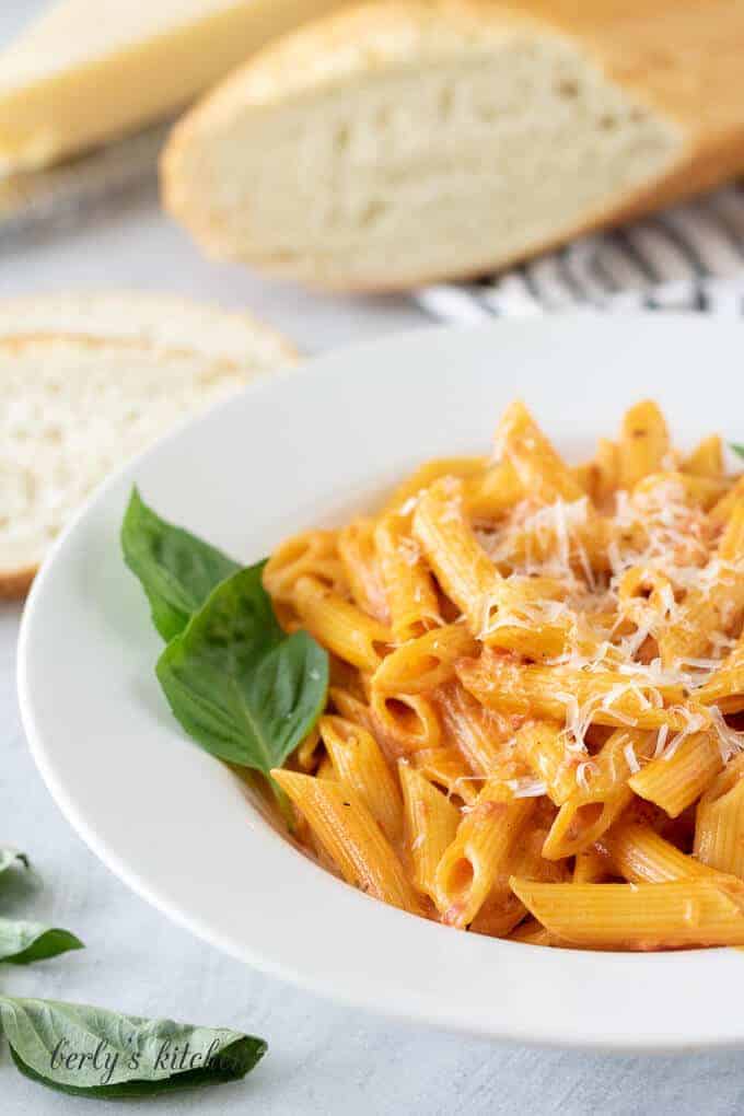 A close-up of the pasta garnished with basil and parmesan.