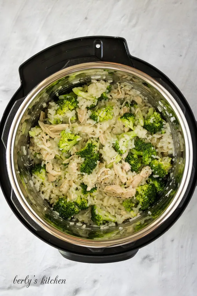 The cooked meat has been shredded and broccoli has been added.