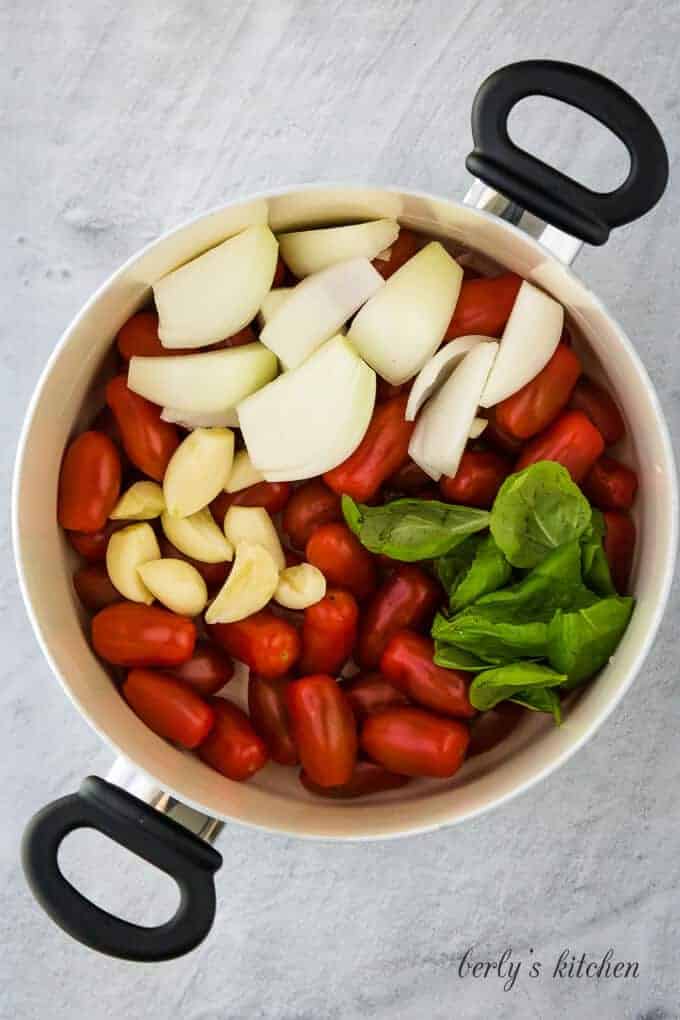 The tomatoes, onions, garlic and other ingredients is a pan.