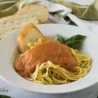 A bowl of spaghetti noodles topped with the marinara sauce.