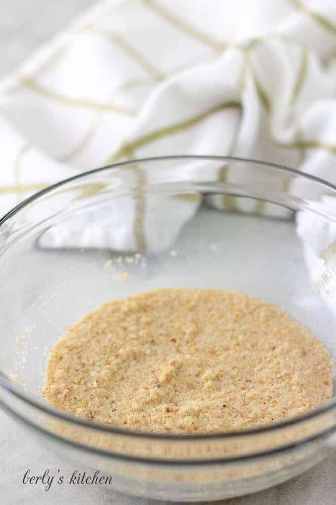 The breadcrumbs and milk mixture in a glass mixing bowl.
