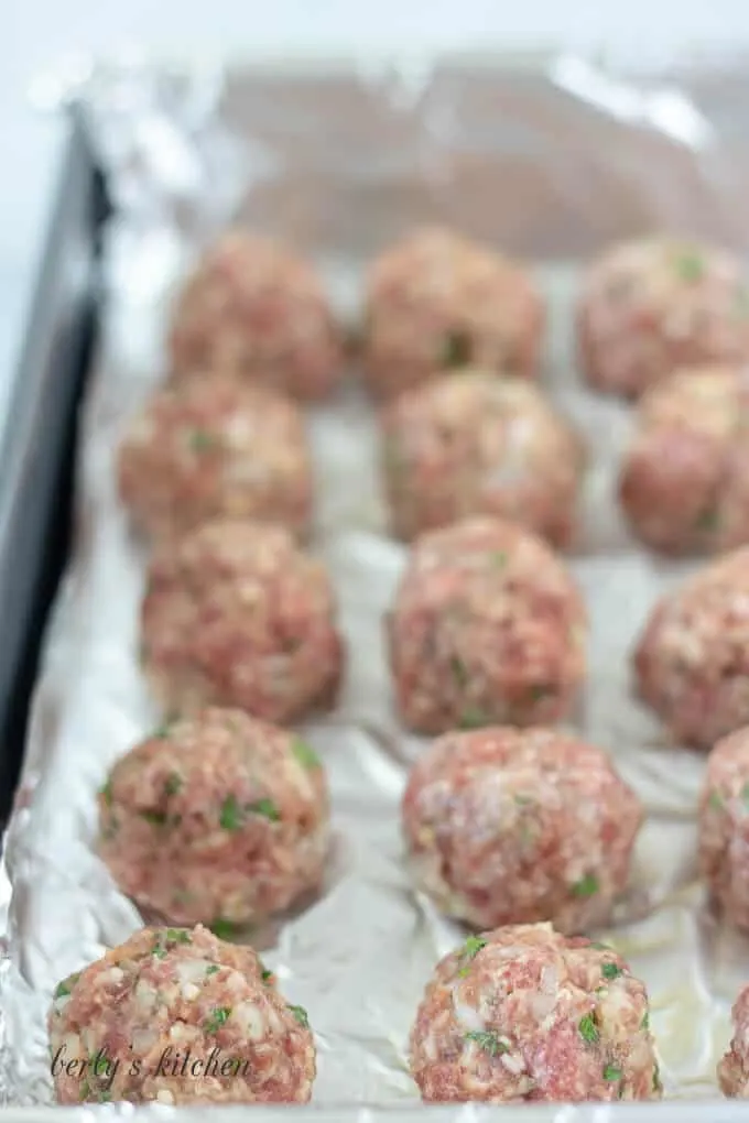 The meatballs have been rolled out and placed on a pan.