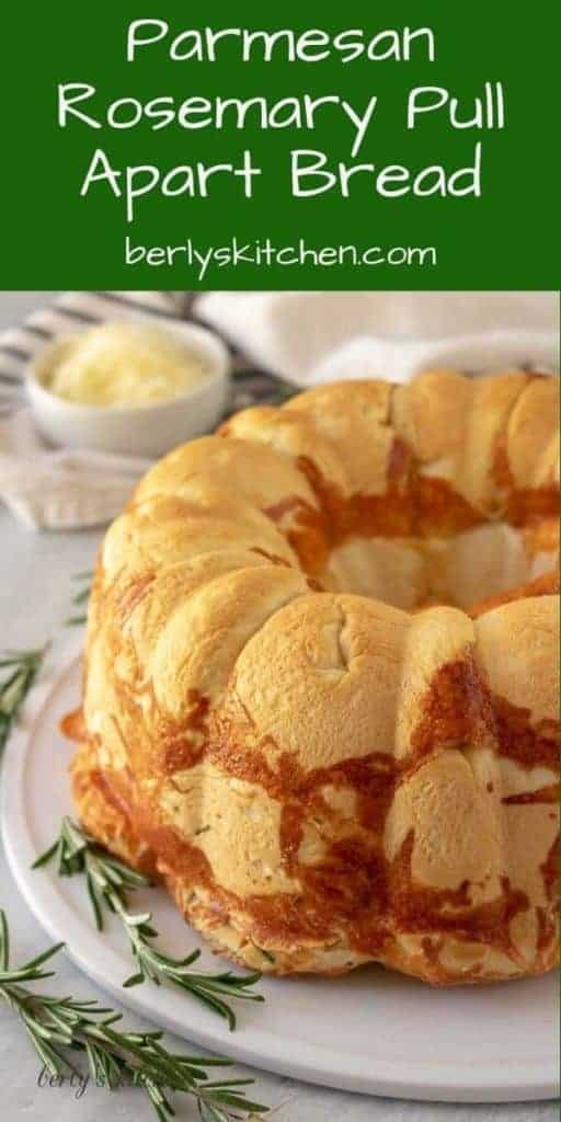 The parmesan rosemary pull apart bread on a plate with herbs.