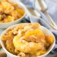 The finished peach cobbler is being served in white bowls.