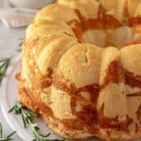 The pull apart bread on a plate with fresh rosemary.