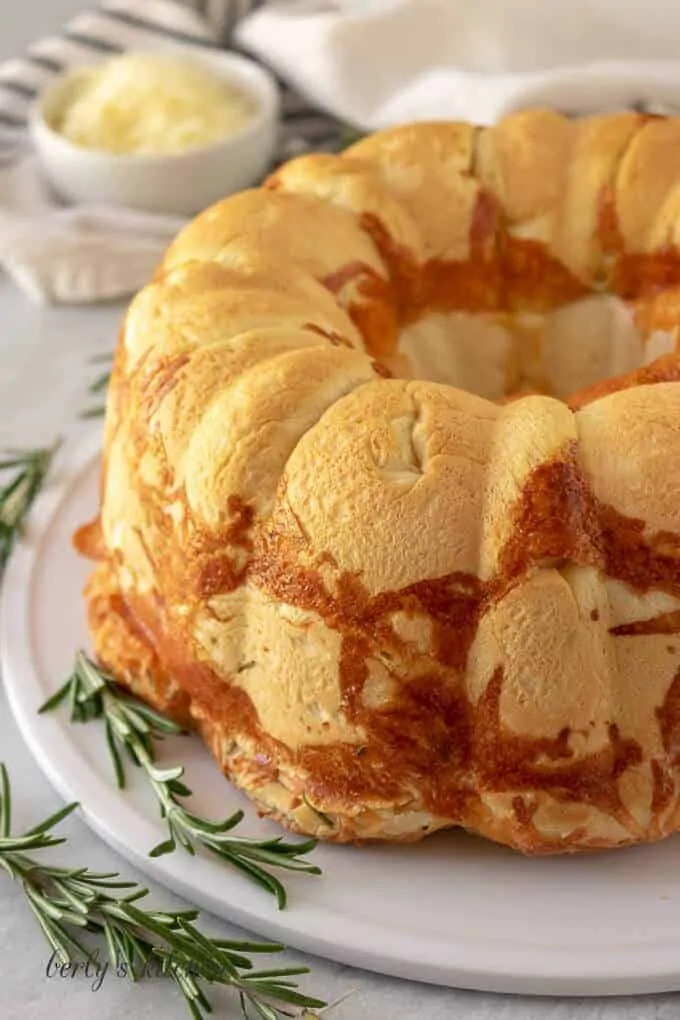 The pull apart bread on a plate with fresh rosemary.