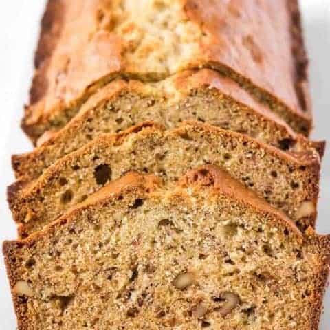 Front facing photo of a loaf of sliced banana bread on a white platter.