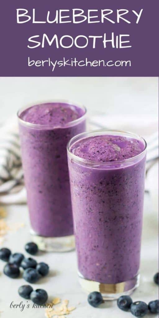 Two blueberry smoothie served in glasses surrounded by fresh berries.