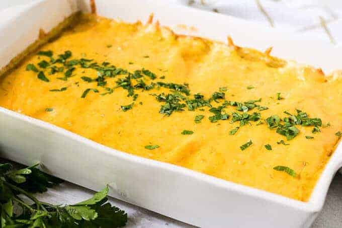 The finished cheesy breakfast enchiladas garnished with chopped fresh parsley.