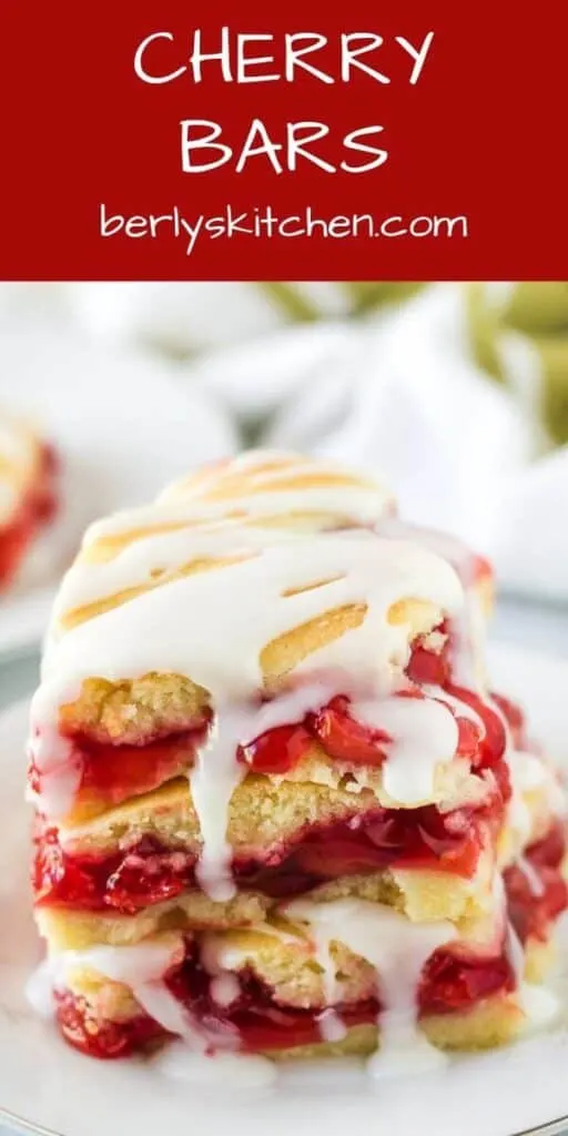 Three cherry bars drizzled with almond icing on a plate.