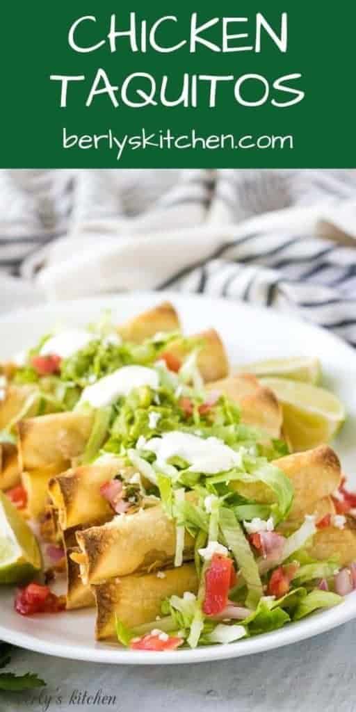 A plate of chicken taquitos served with lettuce, tomatoes, and sour cream.