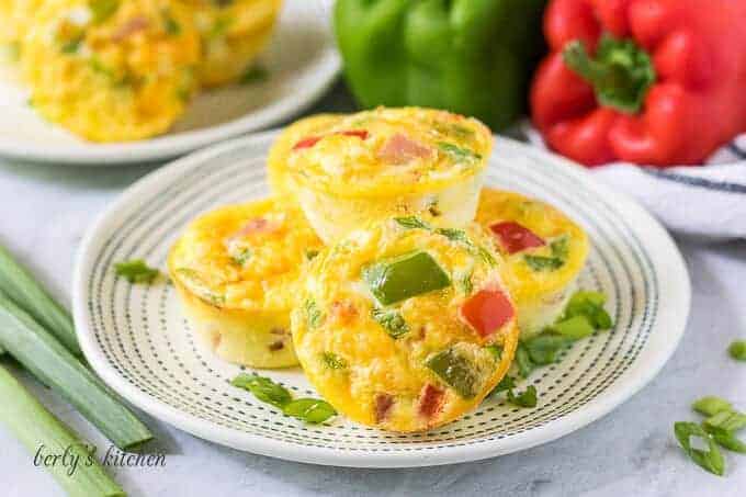 Four Denver omelette muffins stacked on a small decorative plate.