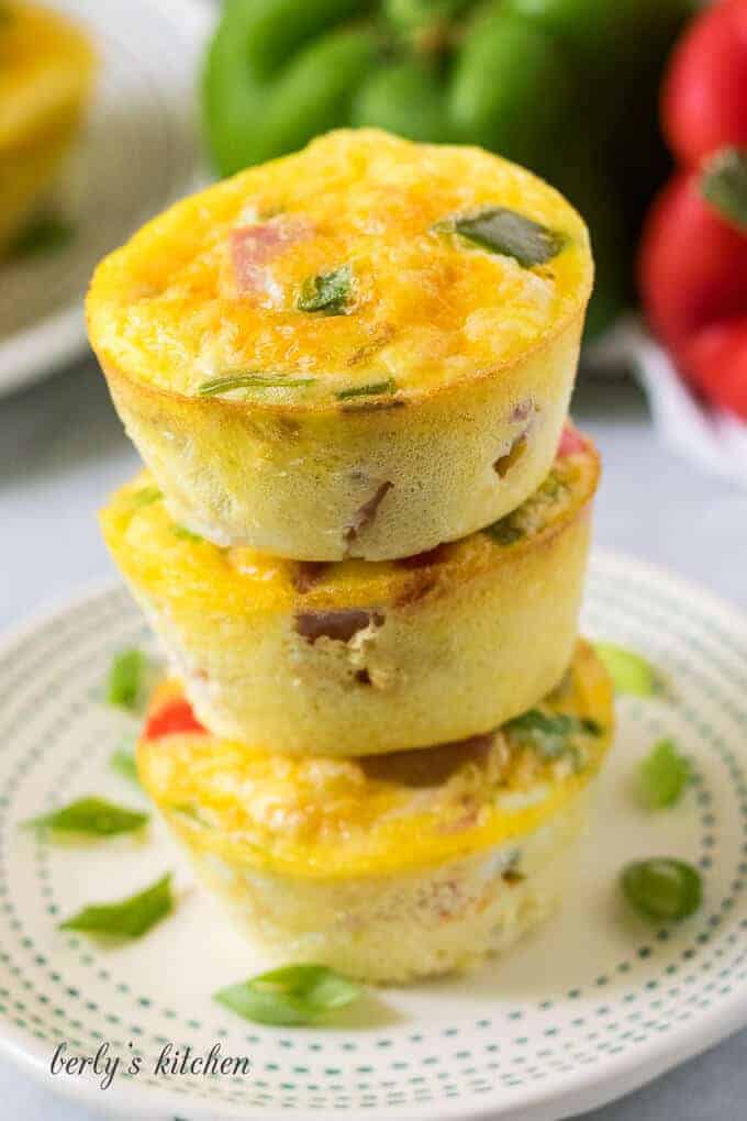 Three stacked egg muffins sitting on a small decorative plate.