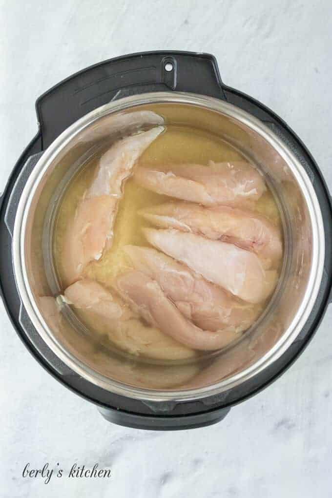 The broth, meat, and rice in the pressure cooker liner.