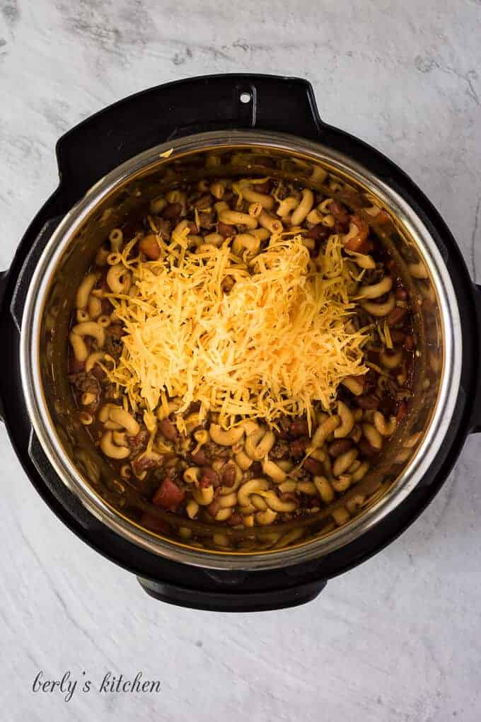 Shredded cheese has been added to finish the chili mac.