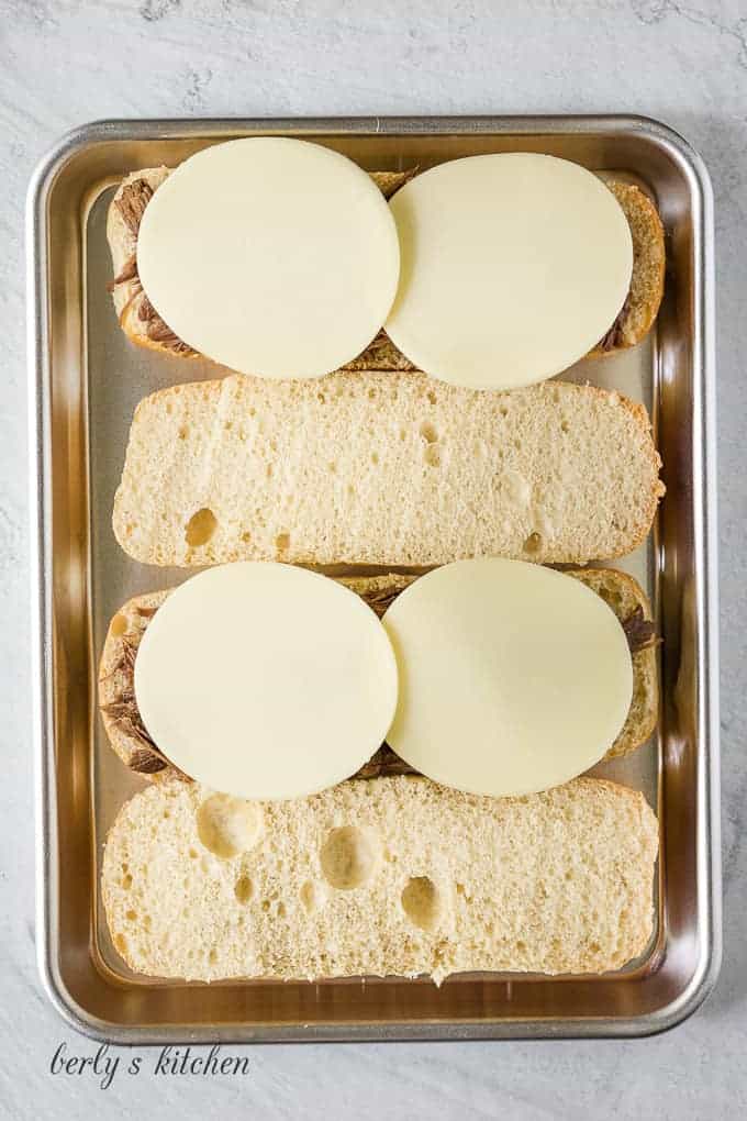 Provolone cheese has been added to the meat to melt.
