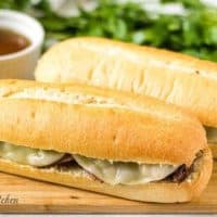 Two Instant Pot French dip sandwiches served with au jus.