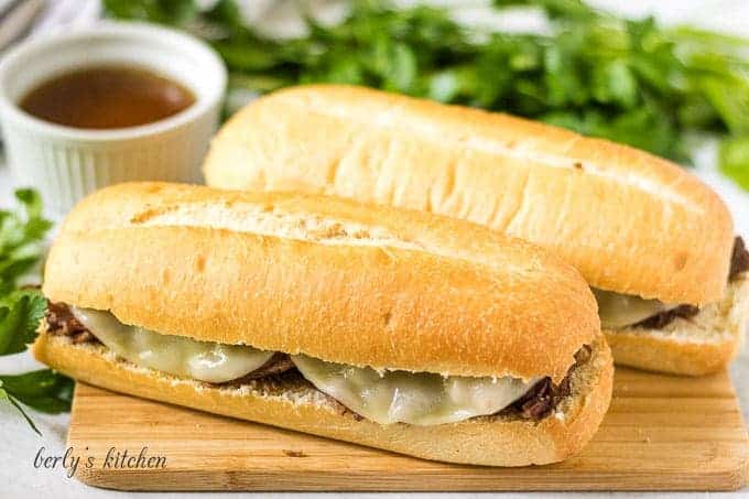 Two Instant Pot French dip sandwiches served with au jus.