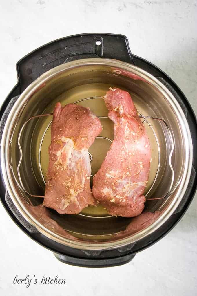 The meat has been halved and placed on the trivet.