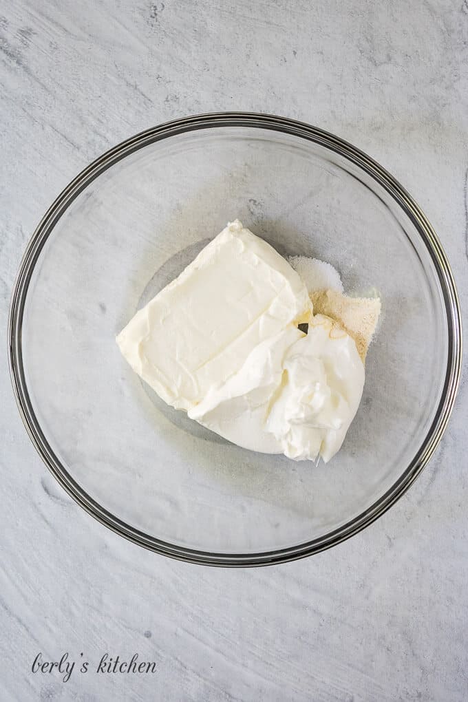 Cream cheese, sour cream, and spices in a mixing bowl.