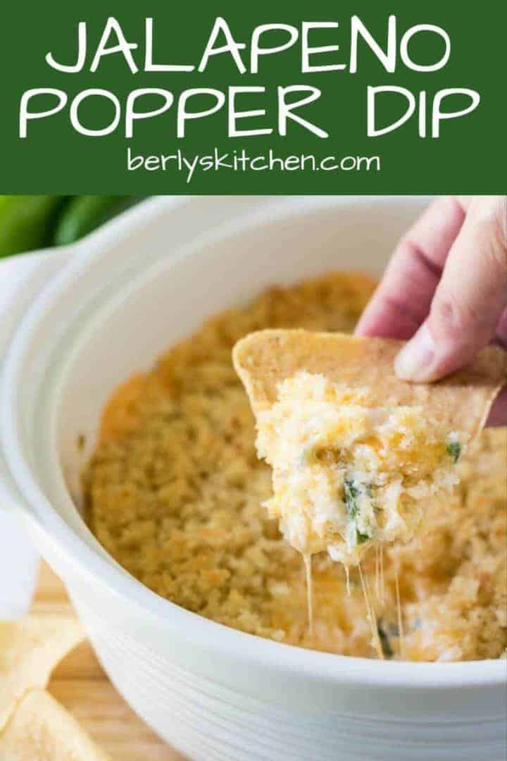 A chip being dipped into the warm jalapeno popper dip.