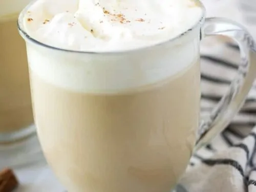 The coffee drink has been garnished with whipped cream and ground cinnamon.