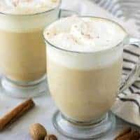 Two mugs of pumpkin spice latte topped with whipped cream.