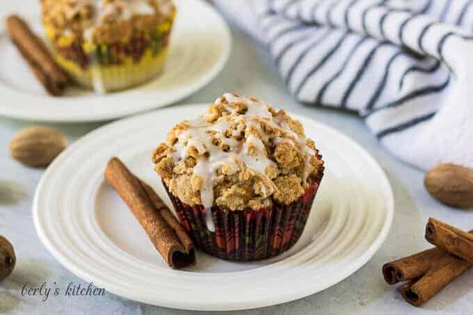 A pumpkin spice muffin on a plate topped with streusel.