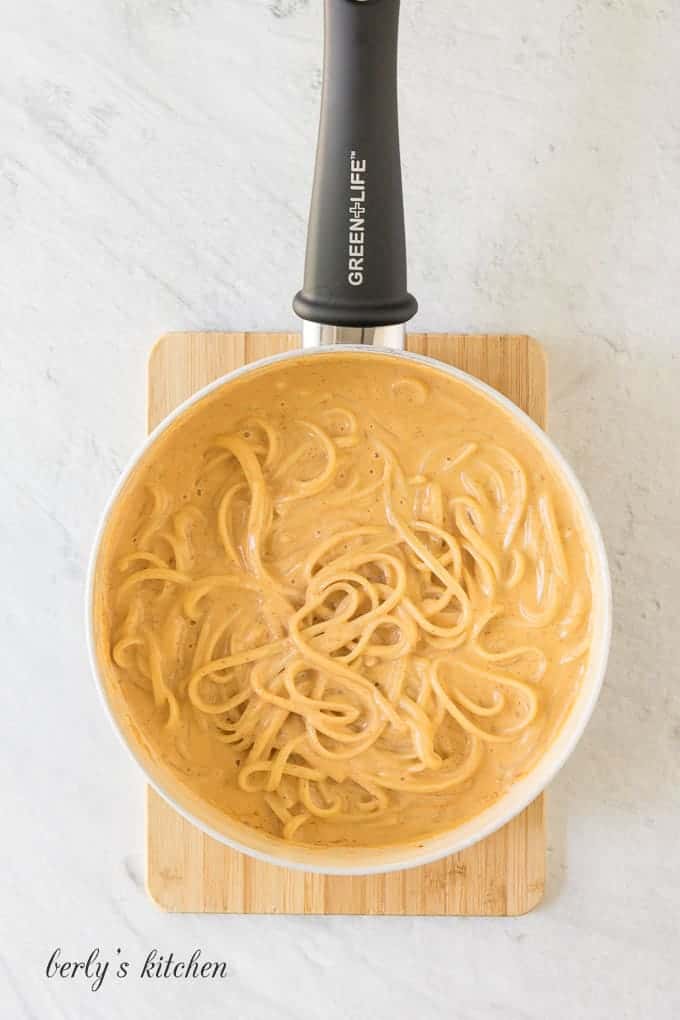 The pasta noodles being tossed in the chipotle cream sauce.